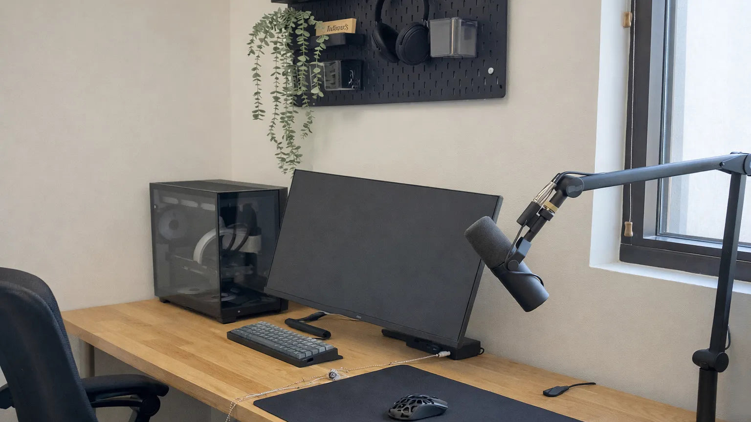 Home office setup with a desk, computer monitor, keyboard, mouse, and microphone.